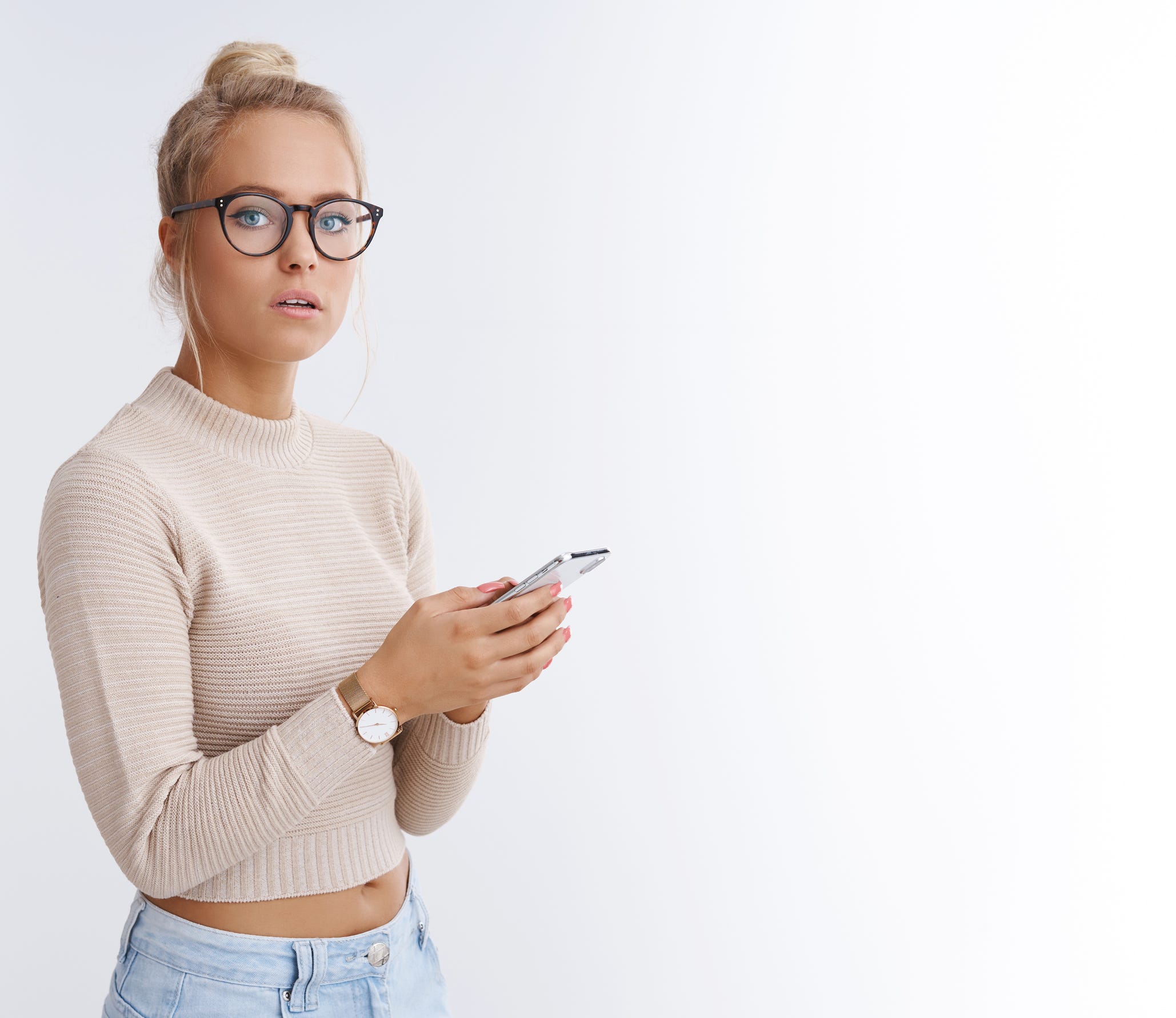 Woman wearing glasses looking up from her cell phone