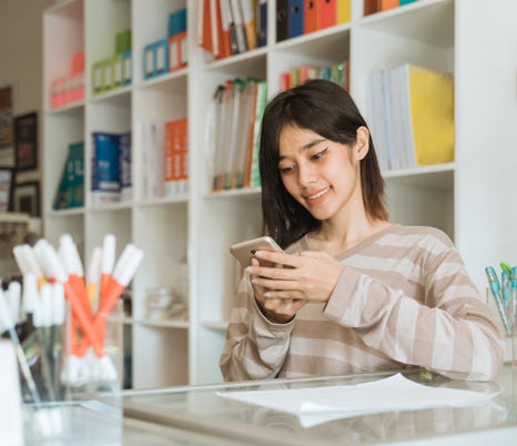 Office worker on her phone at a tidy white desk