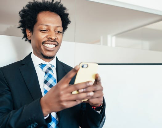 Businessman in a suit using his phone at the office